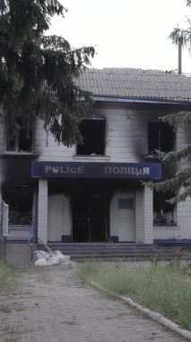 Bu dikey video Ukrayna 'daki savaşın sonucunu gösteriyor. Borodyanka, Kyiv bölgesindeki polis karakolunun yıkılmış ve yanmış binası. Gri, renksiz, düz.