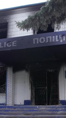 Bu dikey video Ukrayna 'daki savaşın sonucunu gösteriyor. Borodyanka, Kyiv bölgesindeki polis karakolunun yıkılmış ve yanmış binası. Gri, renksiz, düz.