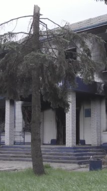 Bu dikey video Ukrayna 'daki savaşın sonucunu gösteriyor. Borodyanka, Kyiv bölgesindeki polis karakolunun yıkılmış ve yanmış binası. Gri, renksiz, düz.