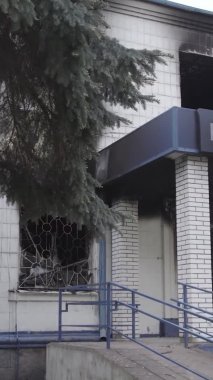 Bu dikey video Ukrayna 'daki savaşın sonucunu gösteriyor. Borodyanka, Kyiv bölgesindeki polis karakolunun yıkılmış ve yanmış binası. Gri, renksiz, düz.