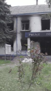 Bu dikey video Ukrayna 'daki savaşın sonucunu gösteriyor. Borodyanka, Kyiv bölgesindeki polis karakolunun yıkılmış ve yanmış binası. Gri, renksiz, düz.