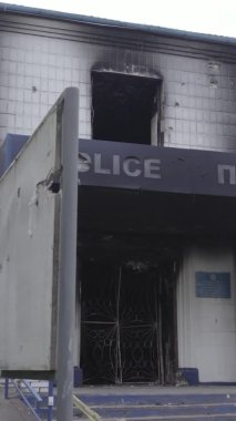 Bu dikey video Ukrayna 'daki savaşın sonucunu gösteriyor. Borodyanka, Kyiv bölgesindeki polis karakolunun yıkılmış ve yanmış binası. Gri, renksiz, düz.