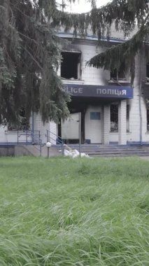 Bu dikey video Ukrayna 'daki savaşın sonucunu gösteriyor. Borodyanka, Kyiv bölgesindeki polis karakolunun yıkılmış ve yanmış binası. Gri, renksiz, düz.