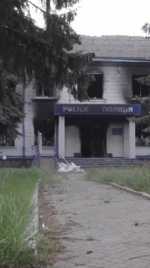Bu dikey video Ukrayna 'daki savaşın sonucunu gösteriyor. Borodyanka, Kyiv bölgesindeki polis karakolunun yıkılmış ve yanmış binası. Gri, renksiz, düz.