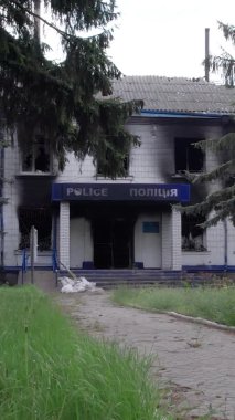 Bu dikey video Ukrayna 'daki savaşın sonucunu gösteriyor. Borodyanka, Kyiv bölgesindeki polis karakolunun yıkılmış ve yanmış binası. Gri, renksiz, düz.