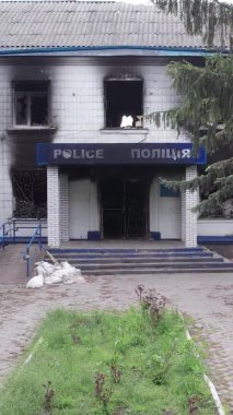 Bu dikey video Ukrayna 'daki savaşın sonucunu gösteriyor. Borodyanka, Kyiv bölgesindeki polis karakolunun yıkılmış ve yanmış binası. Gri, renksiz, düz.