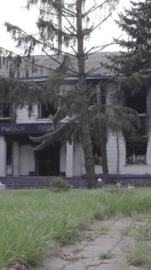 Bu dikey video Ukrayna 'daki savaşın sonucunu gösteriyor. Borodyanka, Kyiv bölgesindeki polis karakolunun yıkılmış ve yanmış binası. Gri, renksiz, düz.