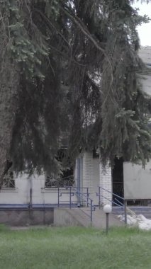 Bu dikey video Ukrayna 'daki savaşın sonucunu gösteriyor. Borodyanka, Kyiv bölgesindeki polis karakolunun yıkılmış ve yanmış binası. Gri, renksiz, düz.