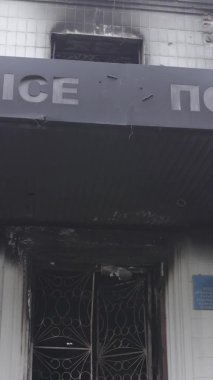 Bu dikey video Ukrayna 'daki savaşın sonucunu gösteriyor. Borodyanka, Kyiv bölgesindeki polis karakolunun yıkılmış ve yanmış binası. Gri, renksiz, düz.