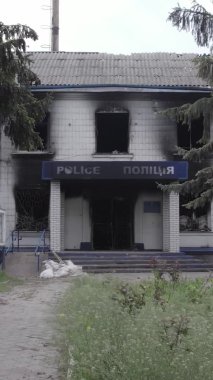Bu dikey video Ukrayna 'daki savaşın sonucunu gösteriyor. Borodyanka, Kyiv bölgesindeki polis karakolunun yıkılmış ve yanmış binası. Gri, renksiz, düz.