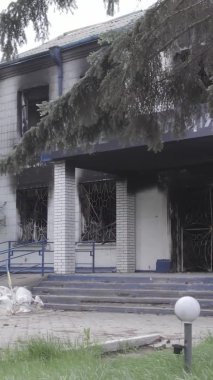 Bu dikey video Ukrayna 'daki savaşın sonucunu gösteriyor. Borodyanka, Kyiv bölgesindeki polis karakolunun yıkılmış ve yanmış binası. Gri, renksiz, düz.