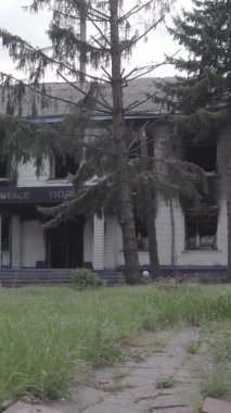 Bu dikey video Ukrayna 'daki savaşın sonucunu gösteriyor. Borodyanka, Kyiv bölgesindeki polis karakolunun yıkılmış ve yanmış binası. Gri, renksiz, düz.
