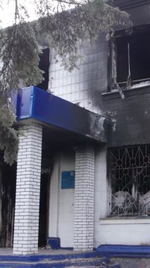 Bu dikey video Ukrayna 'daki savaşın sonucunu gösteriyor. Borodyanka, Kyiv bölgesindeki polis karakolunun yıkılmış ve yanmış binası. Gri, renksiz, düz.