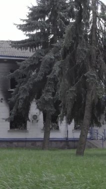 Bu dikey video Ukrayna 'daki savaşın sonucunu gösteriyor. Borodyanka, Kyiv bölgesindeki polis karakolunun yıkılmış ve yanmış binası. Gri, renksiz, düz.