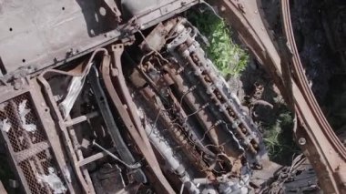 This stock vertical video shows an aerial view of destroyed military equipment in Ukraine, grey, no color, flat