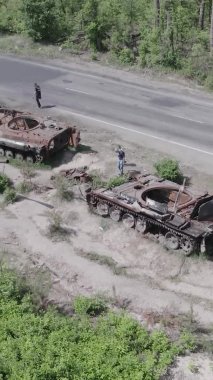 Bu stok dikey video Ukrayna 'daki yok olmuş askeri teçhizatın havadan görüntüsünü gösteriyor, gri, renksiz, düz.