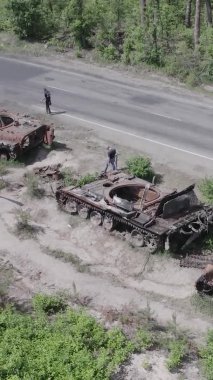 Bu stok dikey video Ukrayna 'daki yok olmuş askeri teçhizatın havadan görüntüsünü gösteriyor, gri, renksiz, düz.