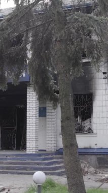 Bu dikey video Ukrayna 'daki savaşın sonucunu gösteriyor. Borodyanka, Kyiv bölgesindeki polis karakolunun yıkılmış ve yanmış binası. Gri, renksiz, düz.