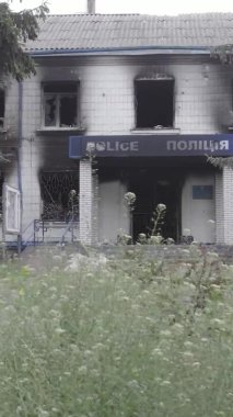 Bu dikey video Ukrayna 'daki savaşın sonucunu gösteriyor. Borodyanka, Kyiv bölgesindeki polis karakolunun yıkılmış ve yanmış binası. Gri, renksiz, düz.