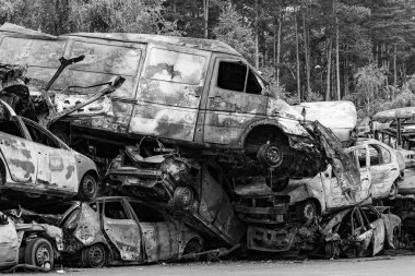 Bu siyah-beyaz fotoğraf Irpin, Bucha bölgesinde bir kurşun ve yanmış araba damlasını gösteriyor.