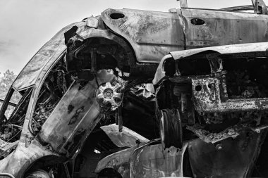 This stock black and white photo shows a dump of shot and burned cars in Irpin, Bucha district, BW