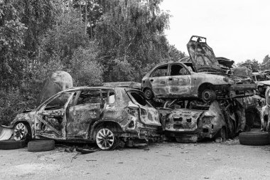 Bu siyah-beyaz fotoğraf Irpin, Bucha bölgesinde bir kurşun ve yanmış araba damlasını gösteriyor.
