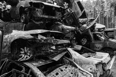 Bu siyah-beyaz fotoğraf Irpin, Bucha bölgesinde bir kurşun ve yanmış araba damlasını gösteriyor.