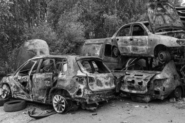 Bu siyah-beyaz fotoğraf Irpin, Bucha bölgesinde bir kurşun ve yanmış araba damlasını gösteriyor.