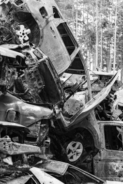 Bu siyah-beyaz fotoğraf Irpin, Bucha bölgesinde bir kurşun ve yanmış araba damlasını gösteriyor.