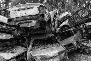 Bu siyah-beyaz fotoğraf Irpin, Bucha bölgesinde bir kurşun ve yanmış araba damlasını gösteriyor.