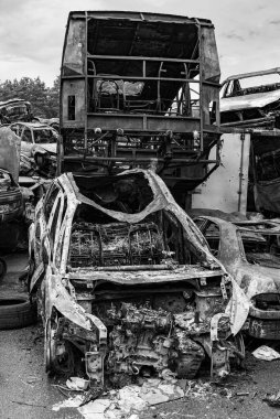 Bu siyah-beyaz fotoğraf Irpin, Bucha bölgesinde bir kurşun ve yanmış araba damlasını gösteriyor.