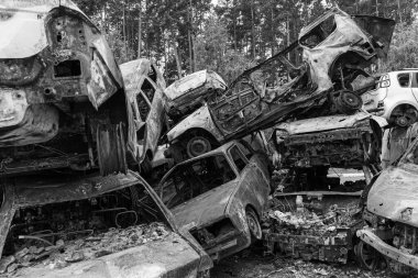 Bu siyah-beyaz fotoğraf Irpin, Bucha bölgesinde bir kurşun ve yanmış araba damlasını gösteriyor.