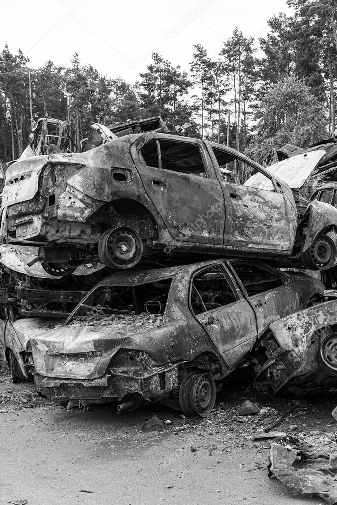 This stock black and white photo shows a dump of shot and burned cars in Irpin, Bucha district, BW
