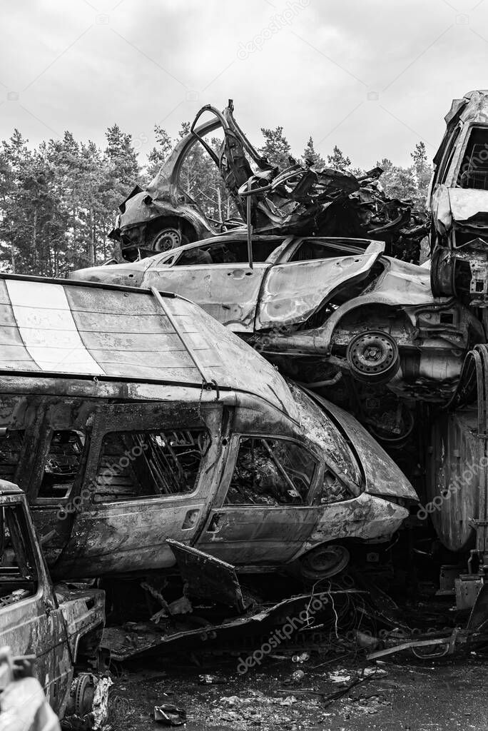 This stock black and white photo shows a dump of shot and burned cars in Irpin, Bucha district, BW