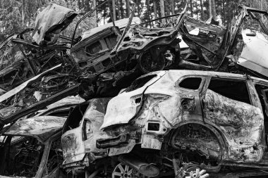 Bu siyah-beyaz fotoğraf Irpin, Bucha bölgesinde bir kurşun ve yanmış araba damlasını gösteriyor.