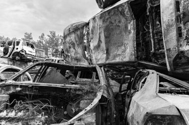 This stock black and white photo shows a dump of shot and burned cars in Irpin, Bucha district, BW