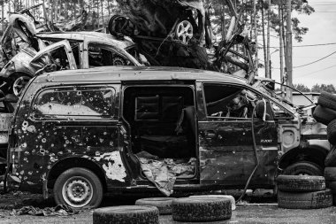 Bu siyah-beyaz fotoğraf Irpin, Bucha bölgesinde bir kurşun ve yanmış araba damlasını gösteriyor.