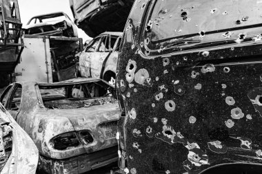 Bu siyah-beyaz fotoğraf Irpin, Bucha bölgesinde bir kurşun ve yanmış araba damlasını gösteriyor.