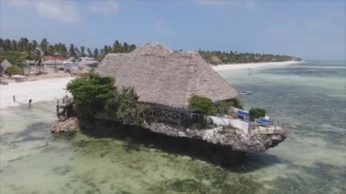 Bu stok video 8K çözünürlükte Tanzanya 'nın Zanzibar kıyısındaki deniz kenarındaki bir evin havadan görüntüsünü gösteriyor.