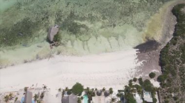 This stock video shows aerial view of a house on stilts in the ocean on the coast of Zanzibar, Tanzania in 8K resolution