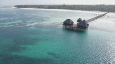 This stock video shows aerial view of a house on stilts in the ocean on the coast of Zanzibar, Tanzania in 8K resolution