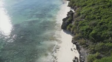 This stock video shows an aerial view of the ocean near the coast of Zanzibar, Tanzania in 8K resolution