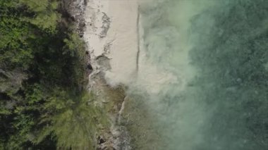 This stock video shows an aerial view of the ocean near the coast of Zanzibar, Tanzania in 8K resolution