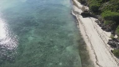 This stock video shows an aerial view of the ocean near the coast of Zanzibar, Tanzania in 8K resolution