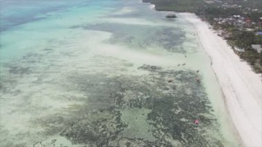 This stock video shows an aerial view of the ocean near the coast of Zanzibar, Tanzania in 8K resolution