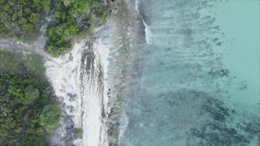 This stock video shows an aerial view of the ocean near the coast of Zanzibar, Tanzania in 8K resolution