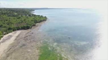 This stock video shows an aerial view of the ocean near the coast of Zanzibar, Tanzania in 8K resolution