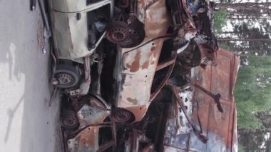 Bu stok dikey video Irpin, Bucha bölgesinde bir kurşun ve yanmış araba dökümü gösteriyor.