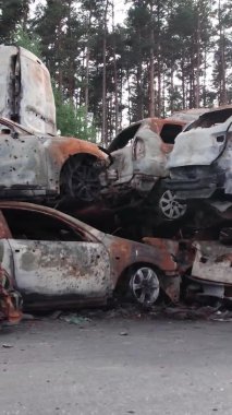 Bu stok dikey video Irpin, Bucha bölgesinde bir kurşun ve yanmış araba dökümü gösteriyor.