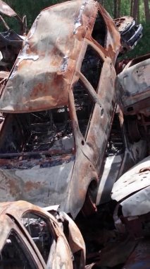 Bu stok dikey video Irpin, Bucha bölgesinde bir kurşun ve yanmış araba dökümü gösteriyor.